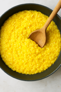 Cooking Risotto alla Milanese in a pan with saffron”