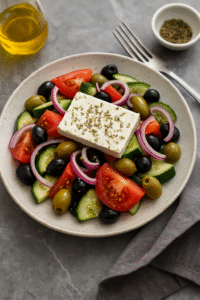 Greek Salad Step 2 – feta cheese and olive oil dressing added to fresh vegetables