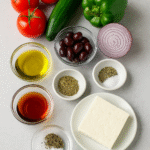 Greek Salad ingredients – tomatoes, cucumber, red onion, green pepper, feta, olives, olive oil, vinegar, oregano
