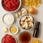 Beef Stroganoff ingredients – beef strips, mushrooms, onion, garlic, sour cream, broth, noodles, mustard, butter