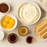 All ingredients for classic Tiramisu: mascarpone, eggs, sugar, espresso, ladyfingers, cocoa, Marsala.