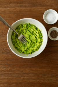 Mashing avocado with salt and pepper for avocado egg toast.