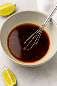 Preparing Spicy Thai Noodles sauce by mixing soy sauce, honey, and sesame oil.