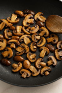 Sautรฉing mushrooms in butter and olive oil for creamy mushroom risotto. ๐