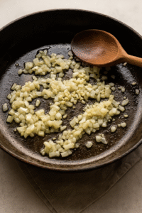 Cooking onion and garlic until fragrant for creamy mushroom risotto base. ๐ง๐ง