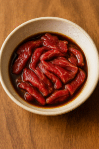 Marinating sliced beef in soy sauce and sesame oil for beef and broccoli stir fry. 🥩