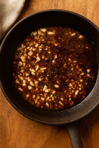 Cooking garlic, ginger, and onion in soy sauce and honey to make the beef and broccoli stir fry sauce. 🍶