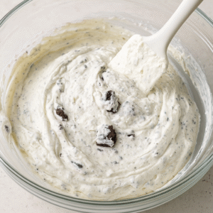 No-Bake Oreo Cheesecake step 2 – creamy mixture of cream cheese, whipped cream, and crushed Oreos in mixing bowl.
