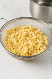 Mac and Cheese step 1 – elbow macaroni freshly boiled and drained in colander.