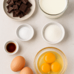 Chocolate Mousse ingredients – dark chocolate, eggs, sugar, heavy cream, vanilla extract, and salt arranged on a kitchen surface.