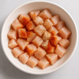 Seasoned chicken pieces for creamy garlic parmesan chicken bites before cooking