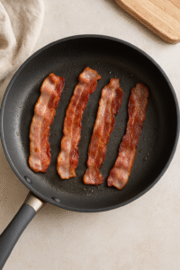 Cooking crispy bacon for Breakfast Burrito on a hot stovetop pan