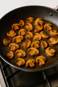 Chicken Marsala Recipe – sautéing sliced mushrooms in melted butter until golden brown in a non-stick pan