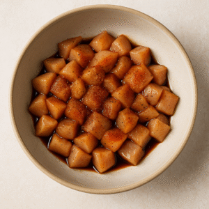 Crispy Garlic Butter Rice with Chicken marinating — cubed chicken in soy sauce, garlic, paprika and seasoning in a ceramic bowl.