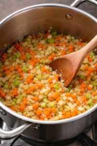 Sautéing onion, carrot, and celery in olive oil for pasta e fagioli soup