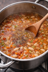 Pasta e fagioli soup simmering with beans and vegetables in a pot