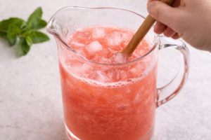 Sweetening and chilling watermelon agua fresca with ice