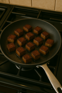 Garlic butter steak cubes – browned steak cubes flipped and cooking evenly in the skillet